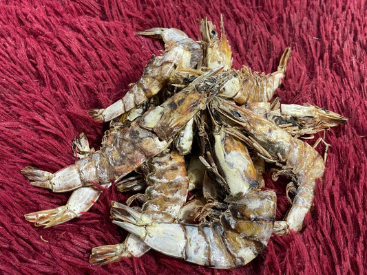 Close-up of dried shrimp piled on textured red fabric background